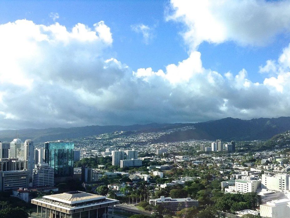 A cityscape with buildings and a mountain in the background.